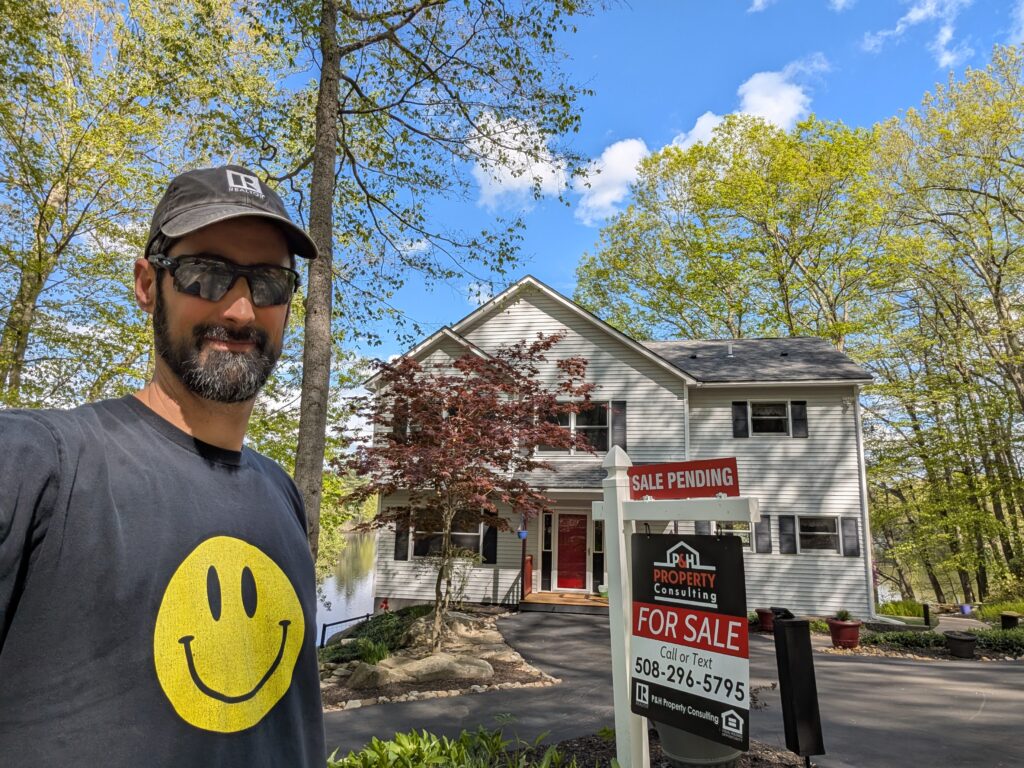 Phil standing with Sale Pending sign
