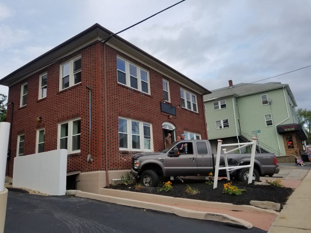 gray truck crashed into front of brick commercial building