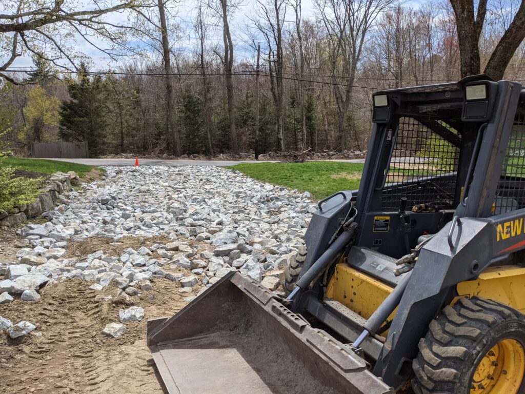 excavator with large rock landscaping